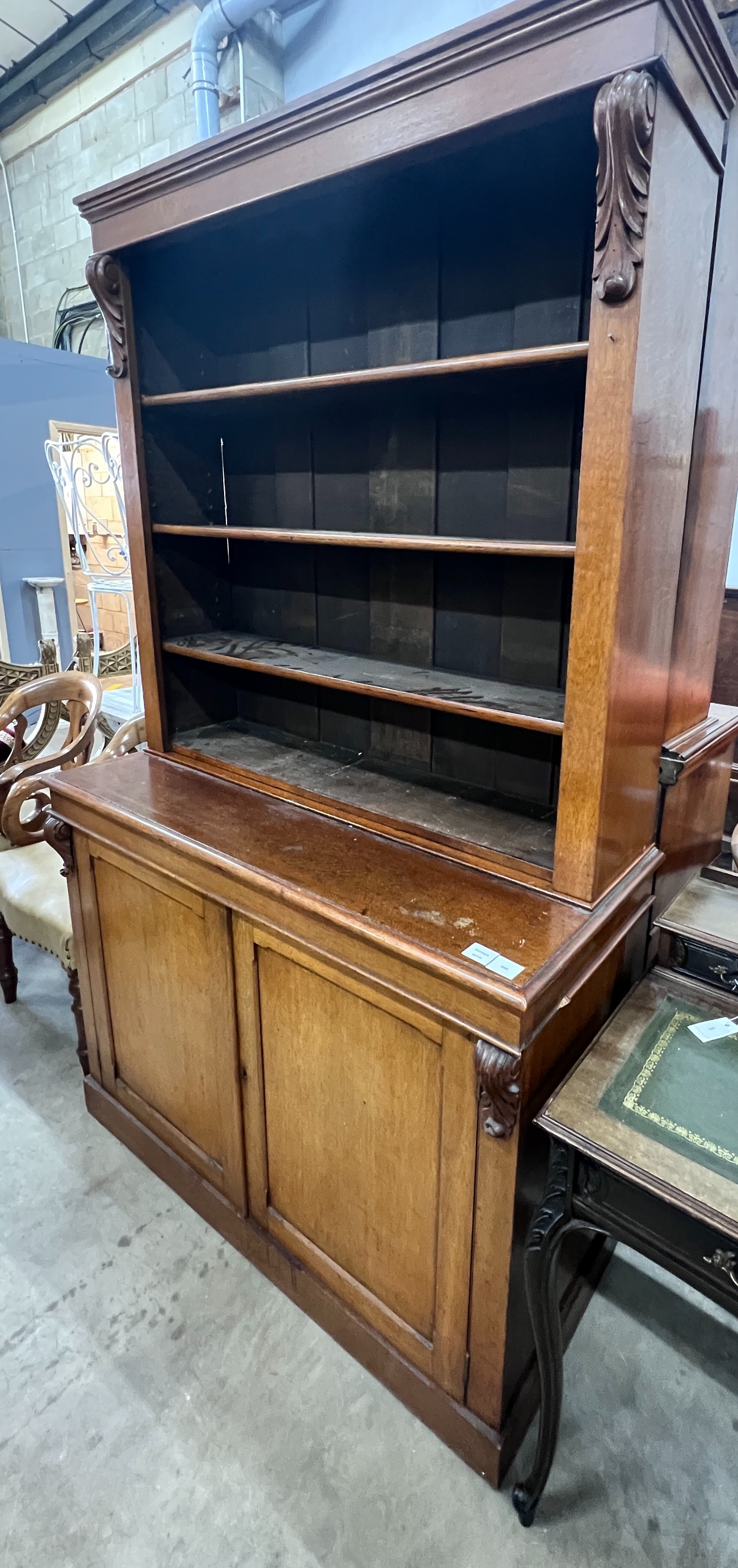 A late Victorian oak bookcase with twin panelled cupboard base, length 122cm, depth 51cm, height 207cm